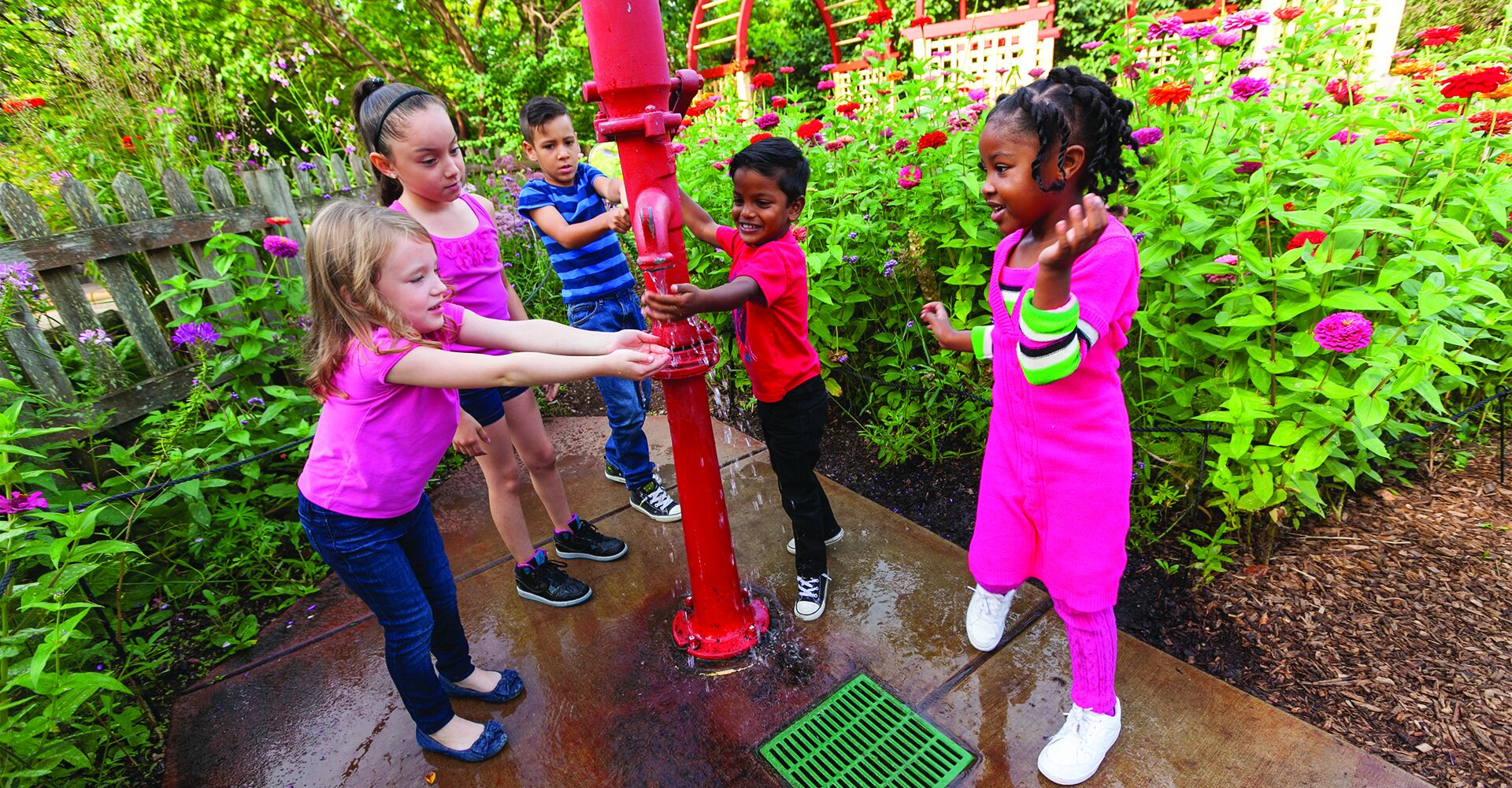 Kids play in water in the children's garden