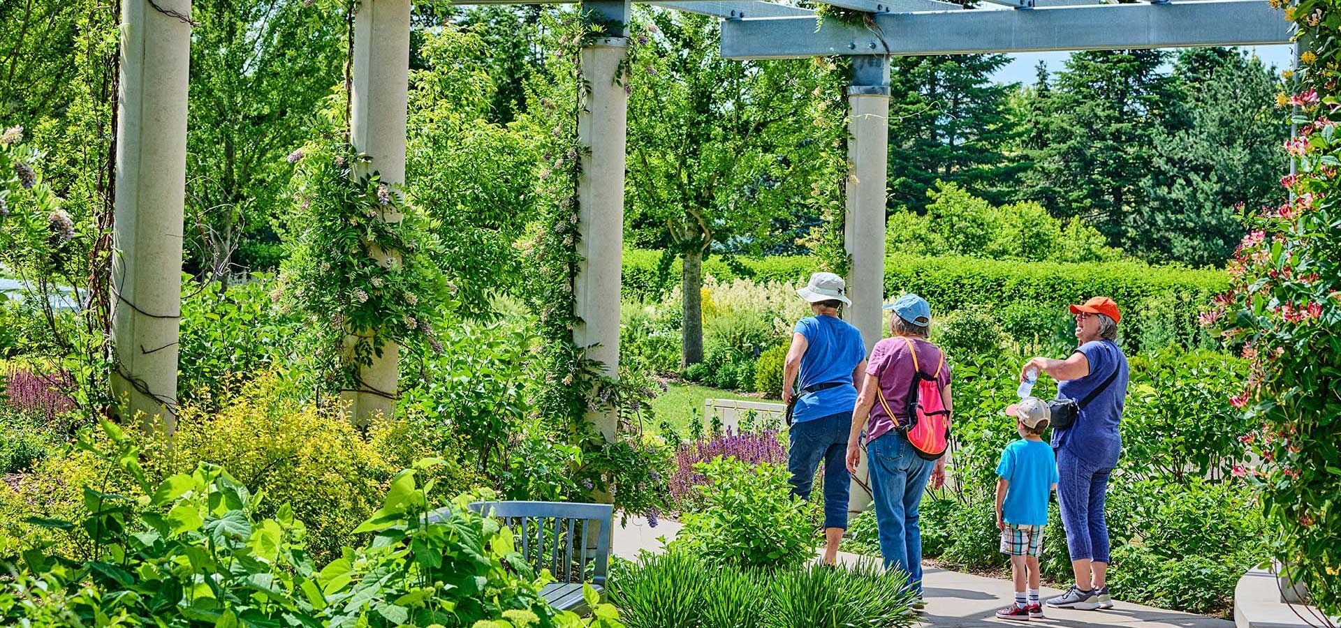 A family with a child gaze at the blooms in the Grand Garden.